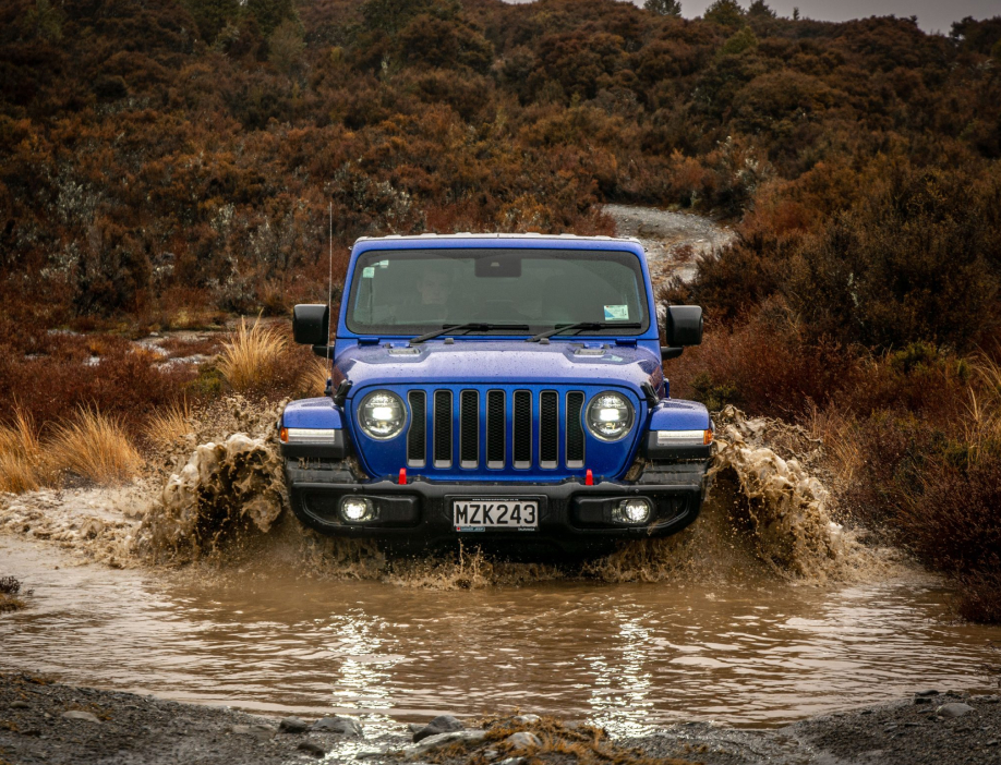 A Jeep drives through a river.