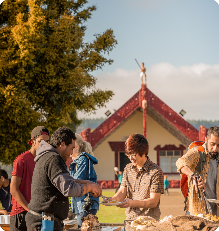 A community gathering around food at a marae.