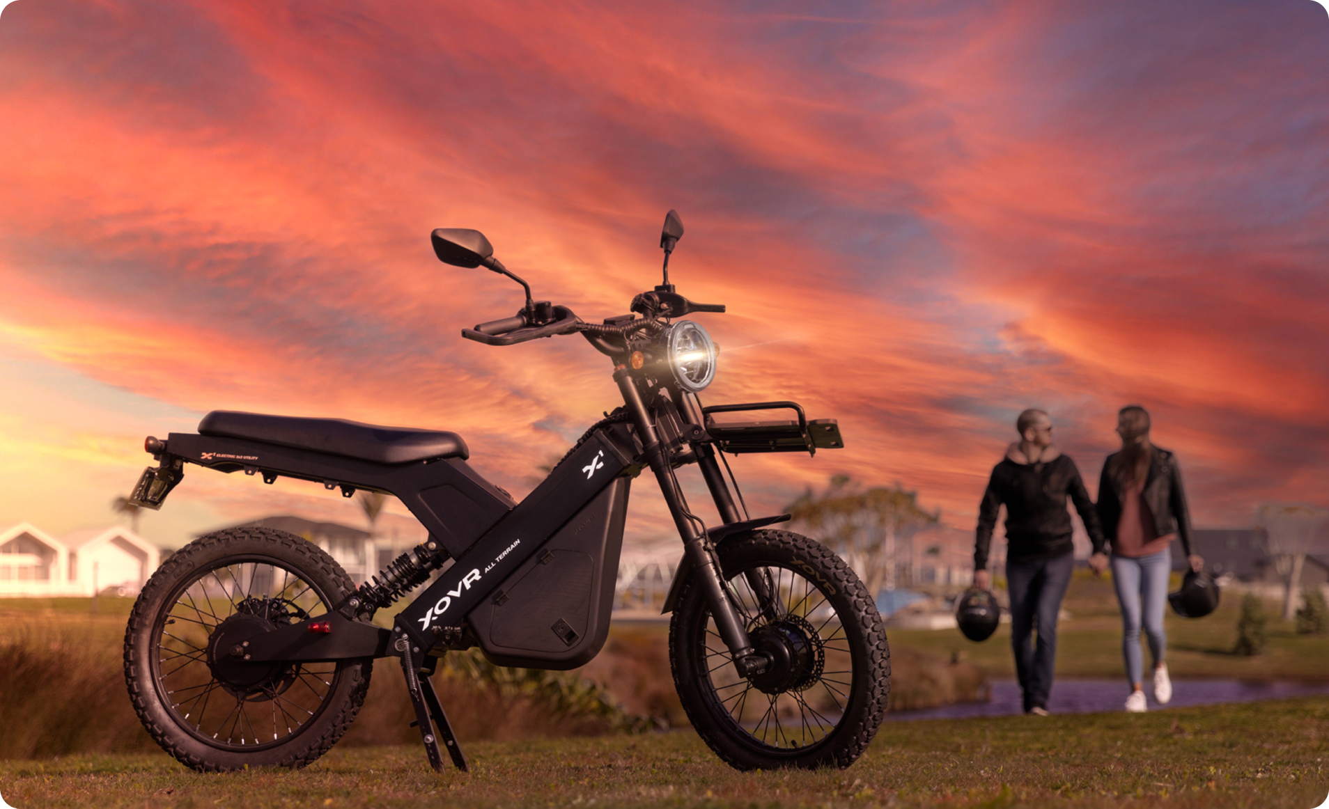 An ebike is in the foreground with a man and woman holding hands in the background.