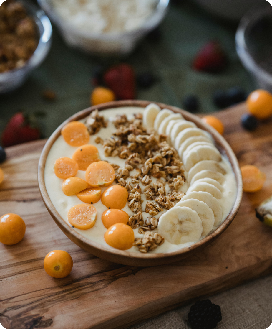 Yoghurt, granola, and fruit are in a bowl.