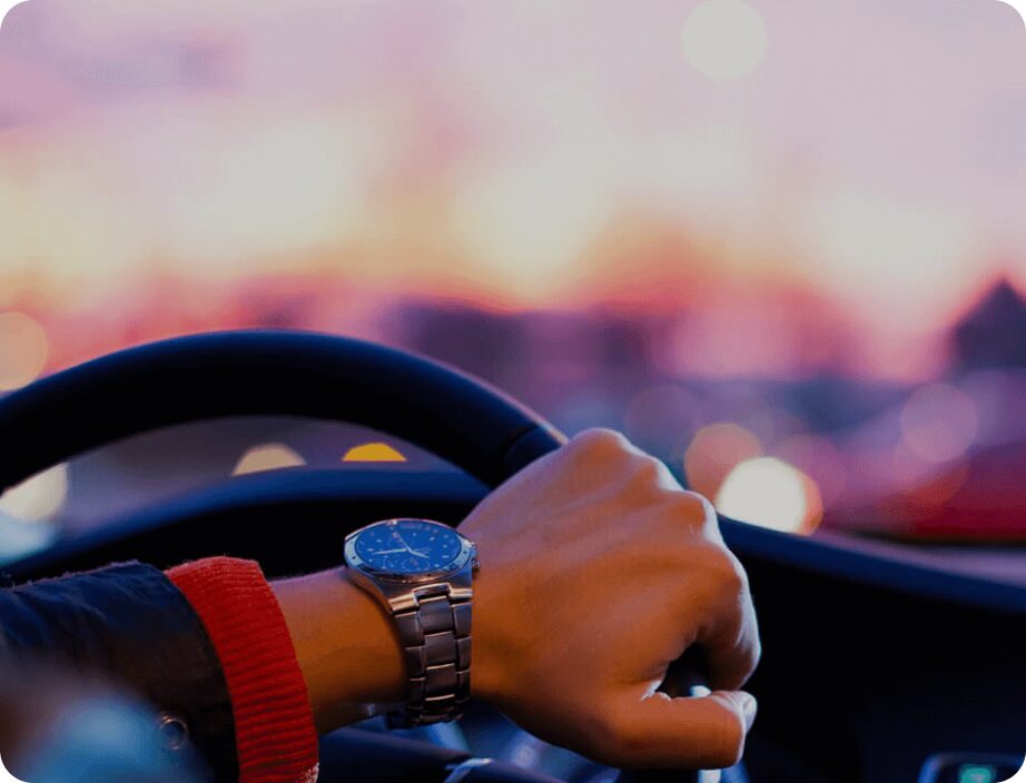 Close up image of a mans hand while driving a car.