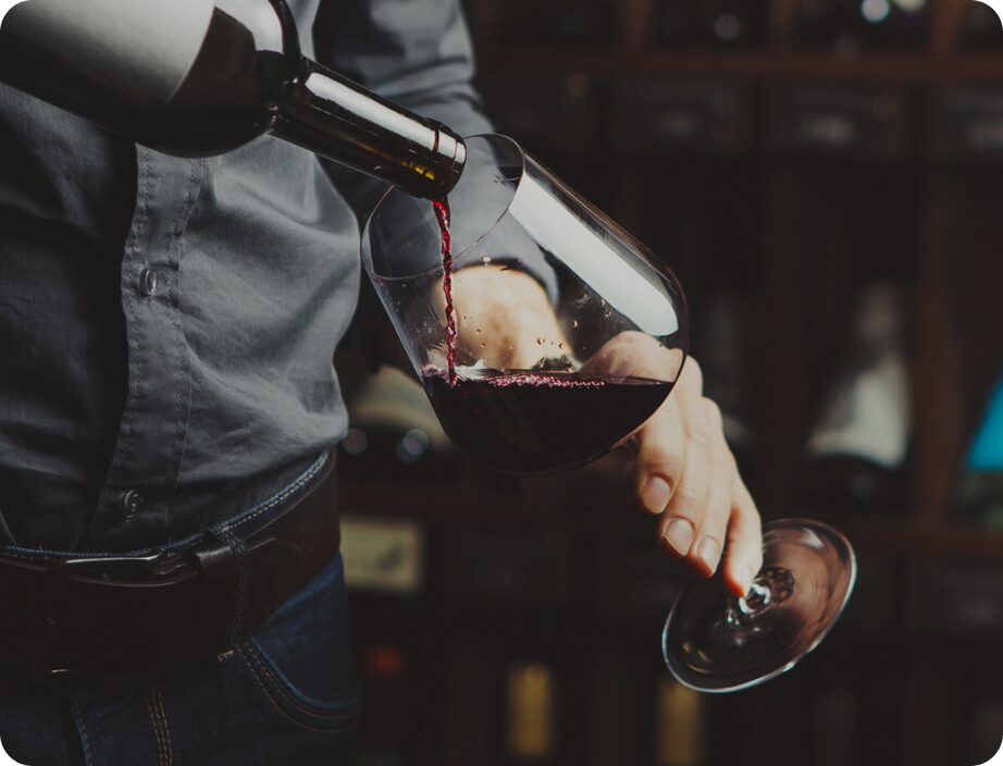 Sommelier from St Heliers Cellar pours a glass of red wine.