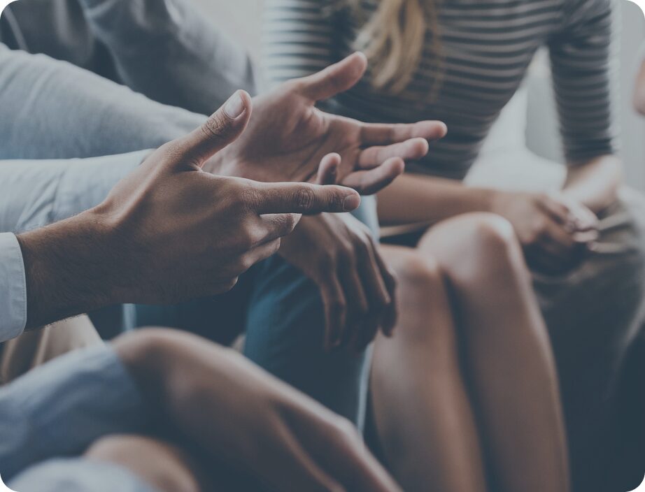 Close up of individuals hands during a group discussion.